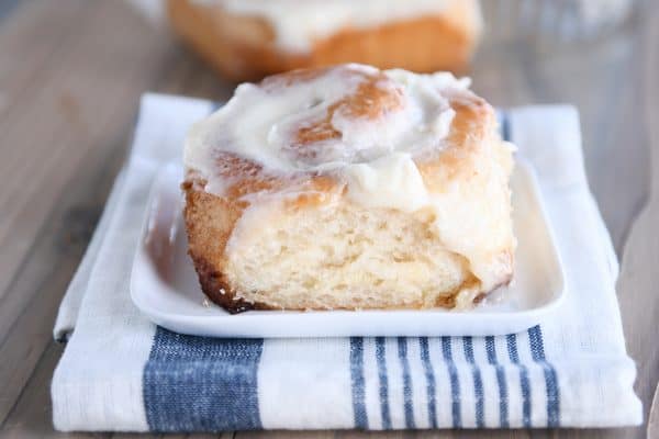 Fluffy cinnamon roll on white plate.