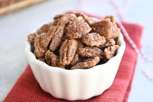 Easy cinnamon and sugar candied pecans in white bowl.