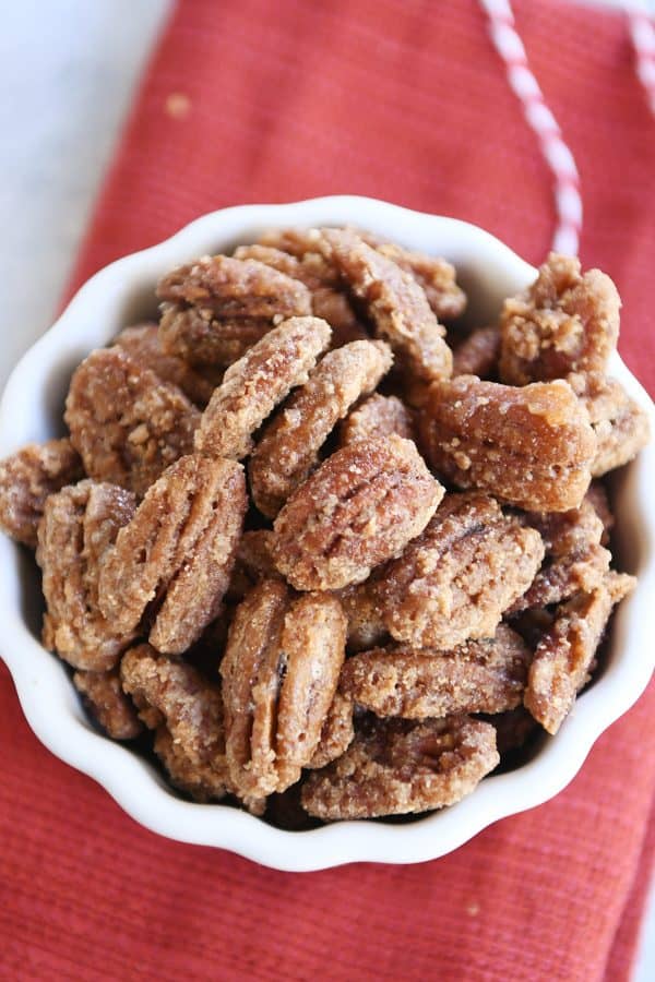 Top down view of white bowl filled with easy cinnamon and sugar candied pecans.