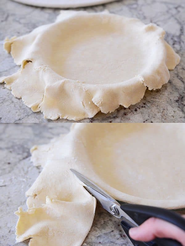 Unbaked pie crust getting the edges trimmed.