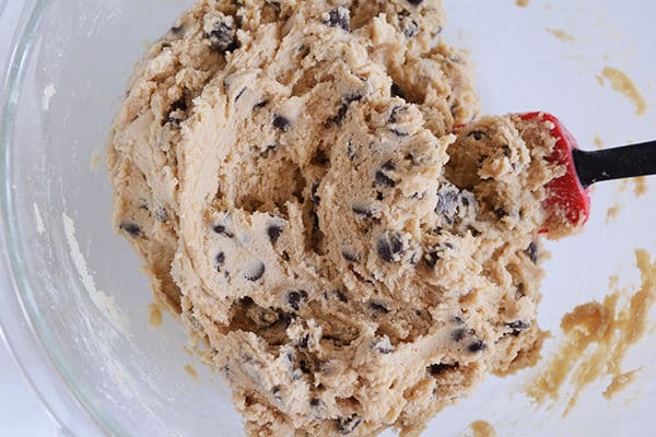 A glass bowl of chocolate chip cookie dough.