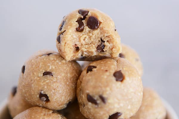 A stack of chocolate chip cookie dough bites, with a bite taken out of the top one.
