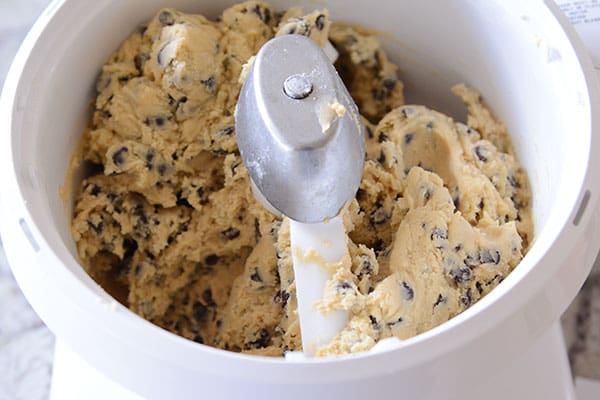 Chocolate chip cookie dough mixing in a white Bosch bowl.