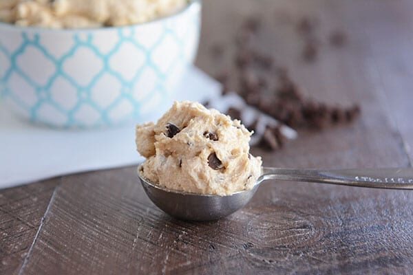A metal tablespoon full of cookie dough frosting.