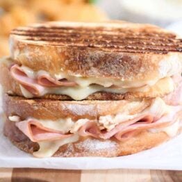 Two chicken cordon bleu panini sandwiches stacked on top of each other.