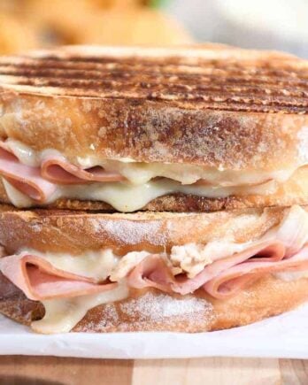 Two chicken cordon bleu panini sandwiches stacked on top of each other.