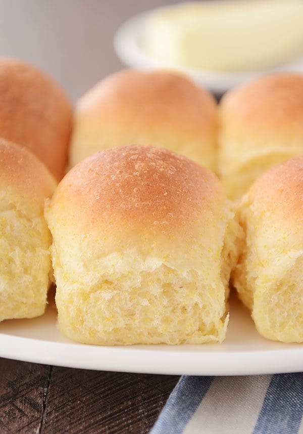 A plate of golden brown cooked cornmeal dinner rolls.