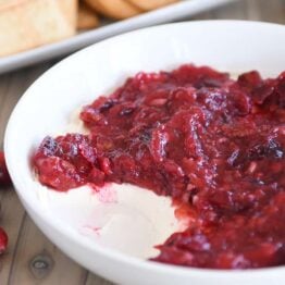 Cranberry pecan cream cheese dip in white bowl.