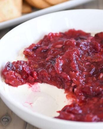 Cranberry pecan cream cheese dip in white bowl.
