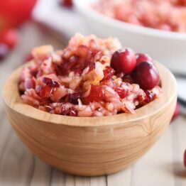 Fresh cranberry apple relish small serving in wood bowl.