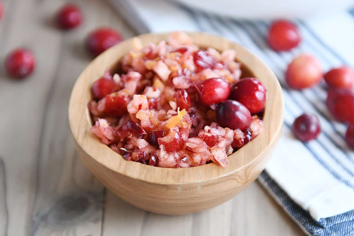 Fresh cranberry apple relish small serving in wood bowl.