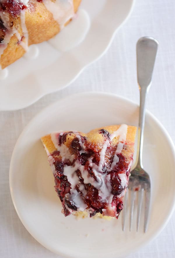 Top view of a piece of cranberry topped bundt cake with a bite taken out.