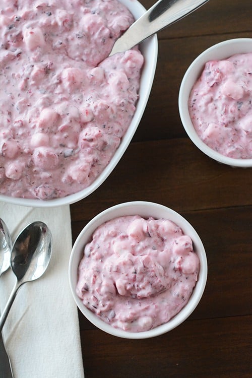 Top view of a big dish and two smaller bowls of cranberry fluff salad.