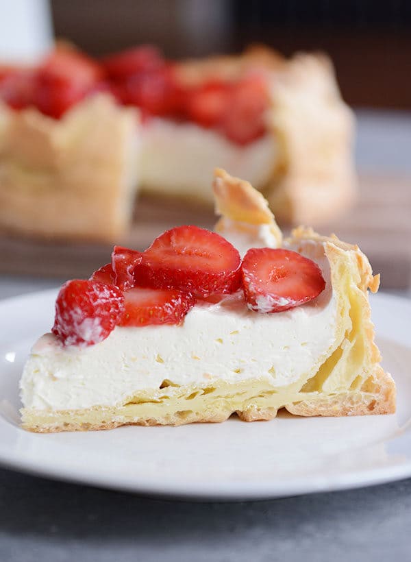 A slice of strawberry cream puff cake on a white plate.