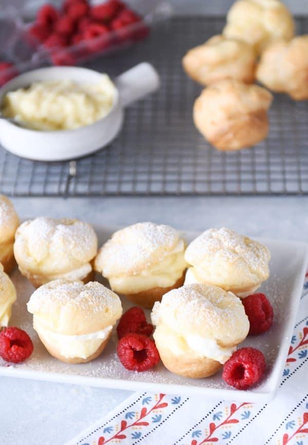 White tray of foolproof cream puffs and raspberries.