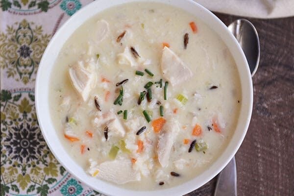 Top view of a white bowl of chicken, veggie, and wild rice soup.