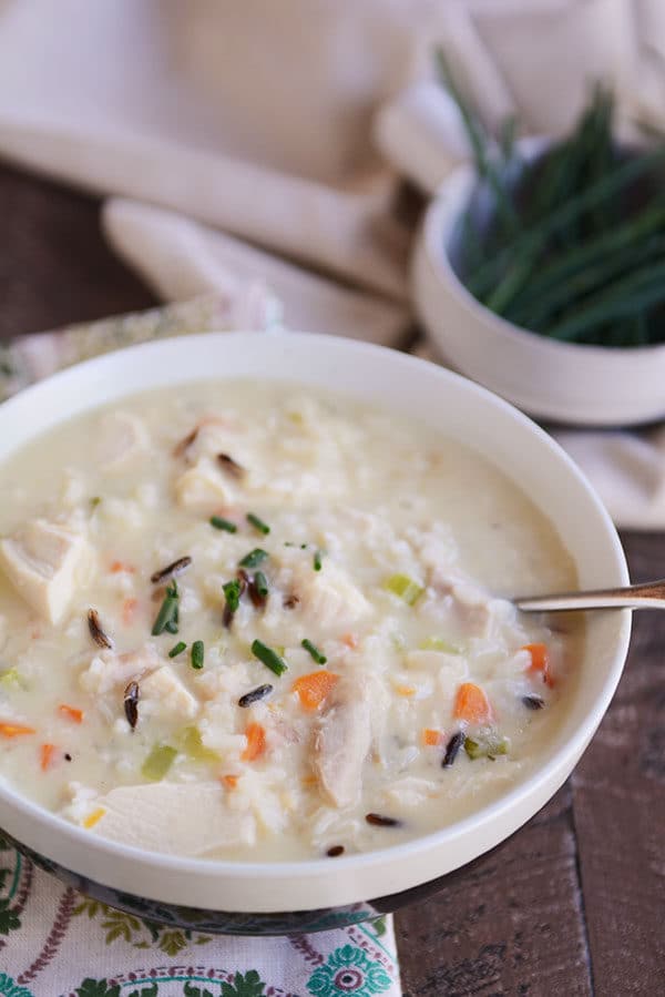 A white bowl full of creamy chicken and wild rice soup.
