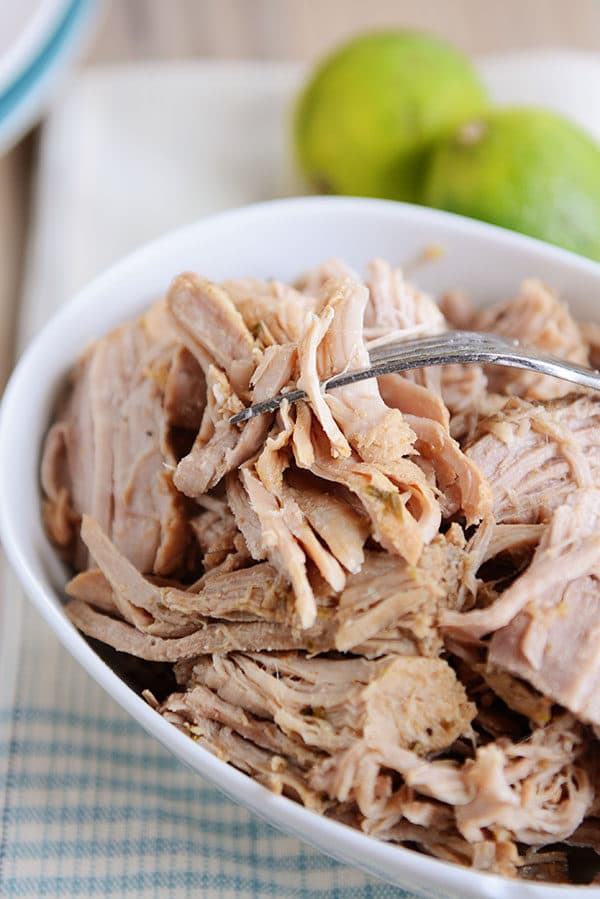 A white oval dish full of shredded pork. 