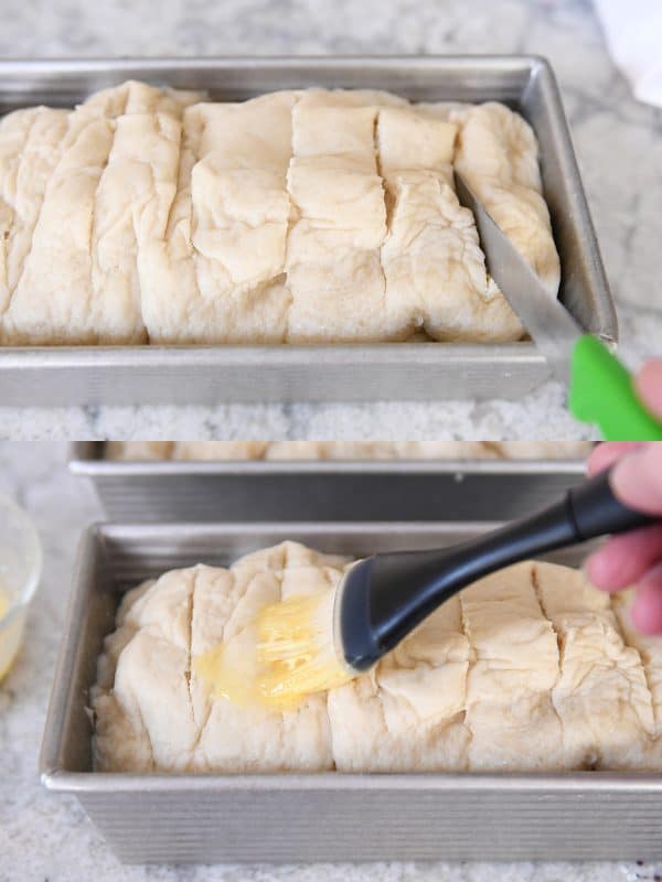 Uncooked bagel bread getting slits cut in the top and butter brushed on top.