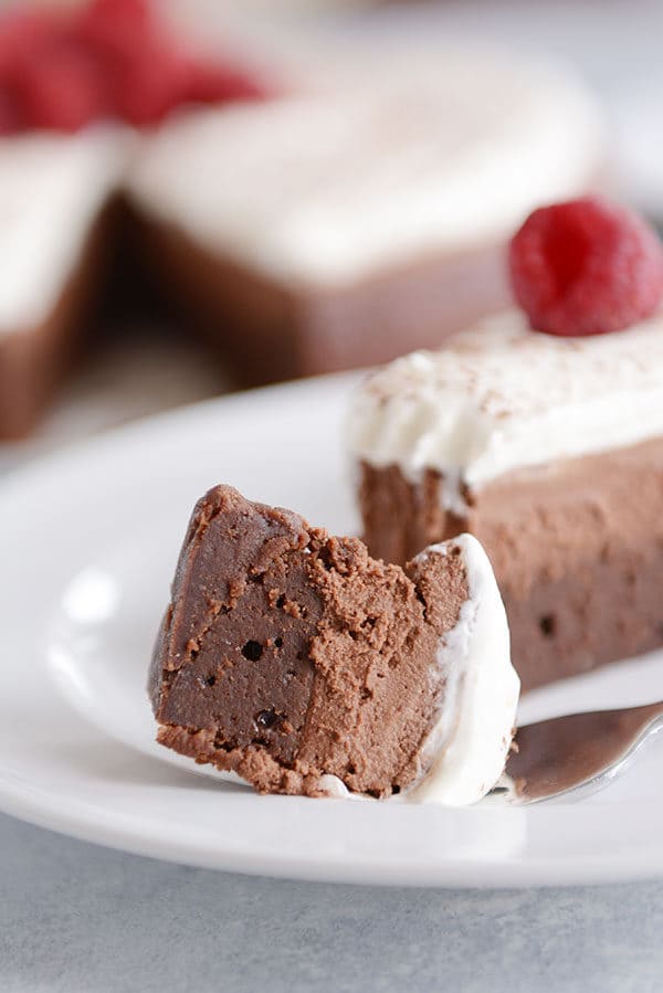 A slice of double chocolate mousse torte with a bite taken out. 