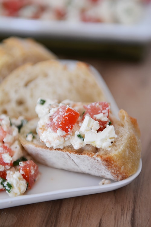 A sliced baguette topped with a Greek feta dip. 