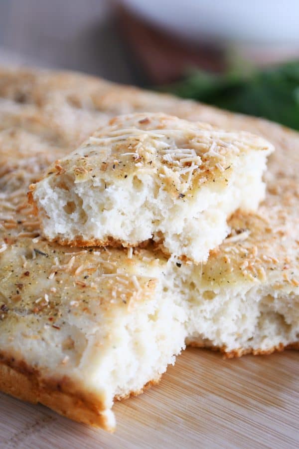 Easy focaccia bread with piece on top of loaf.