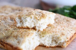 Easy focaccia bread with piece on top of loaf.