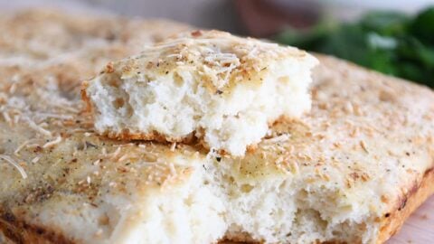 Easy focaccia bread with piece on top of loaf.