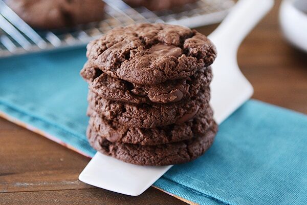 A stack of chocolate cookies on a metal spatula.