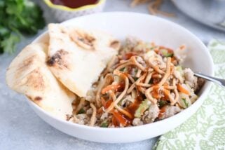 Ground turkey, cabbage, naan in white bowl drizzled with sweet and sour sauce.