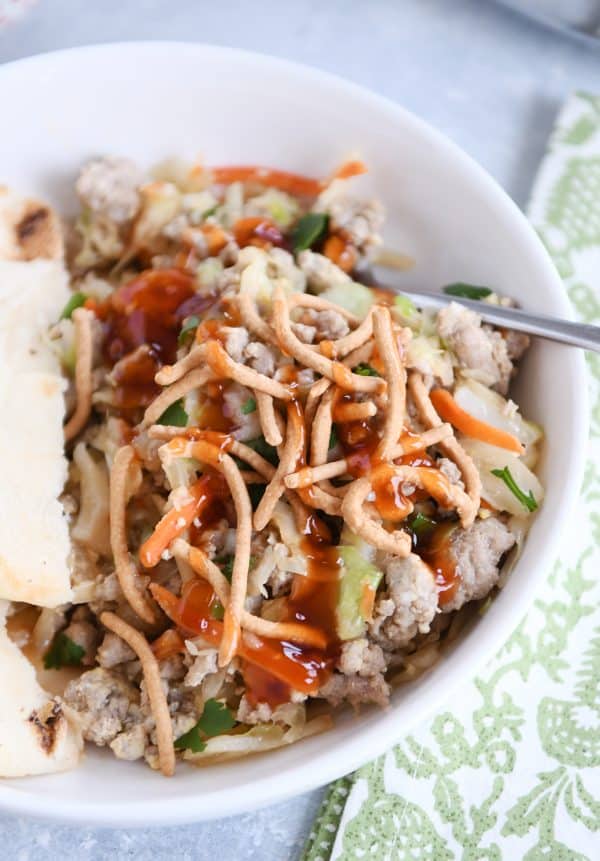 Ground turkey, cabbage, naan in white bowl drizzled with sweet and sour sauce.