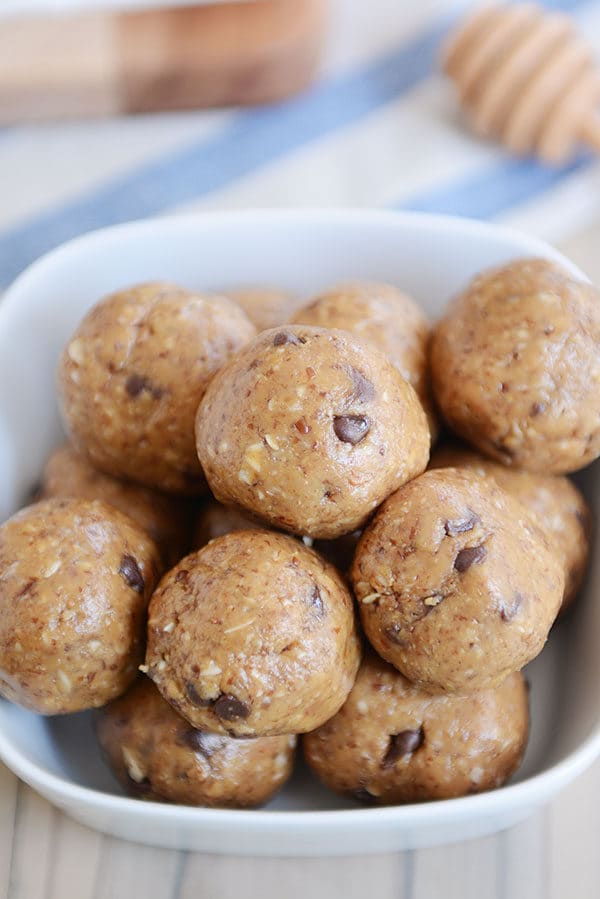 A white bowl full of chocolate chip peanut butter protein bites. 