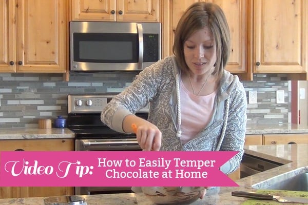 A woman stirring a bowl of melted chocolate.