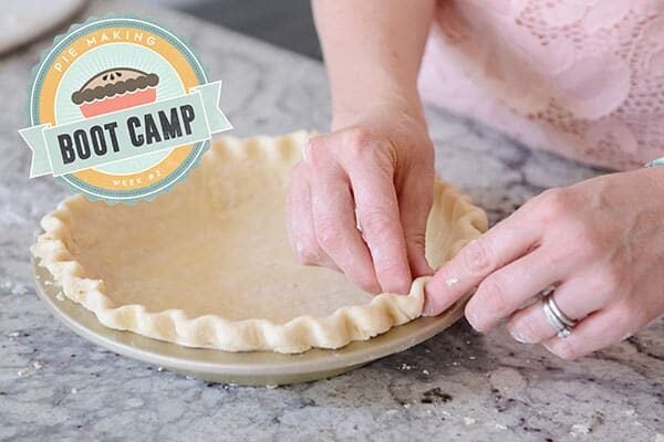 A raw pie crust getting the edges crimped.