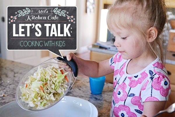 A little girl pouring salad into a white platter. 