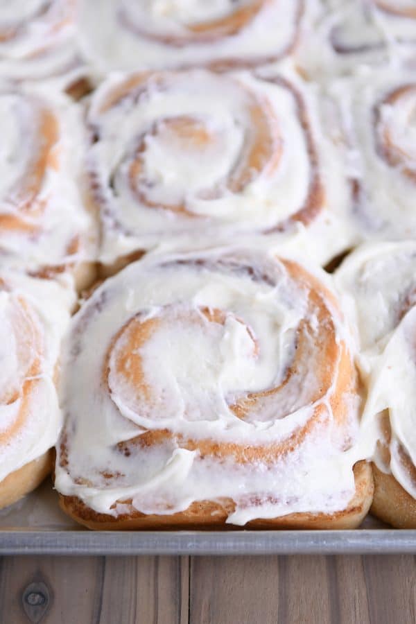 Half sheet pan with frosted cinnamon rolls.