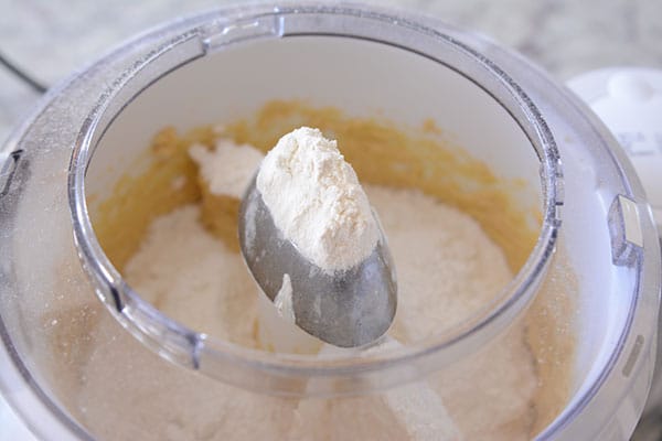 Butter, flour, and sugar mixing in a white Bosch bowl.