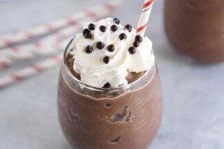 Frozen hot chocolate in clear glass with whipped cream and straw.