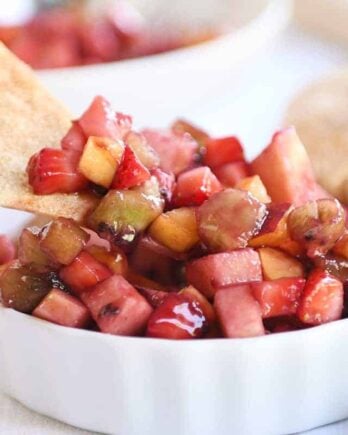 Small white bowl with fruit salsa with baked cinnamon tortilla chips.