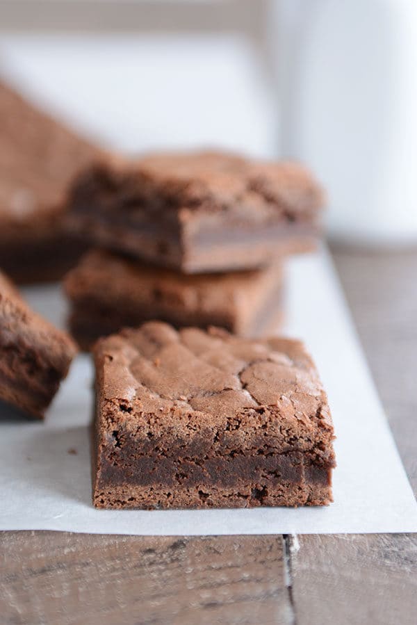 Cut up fudgy brownies on a piece of parchment.