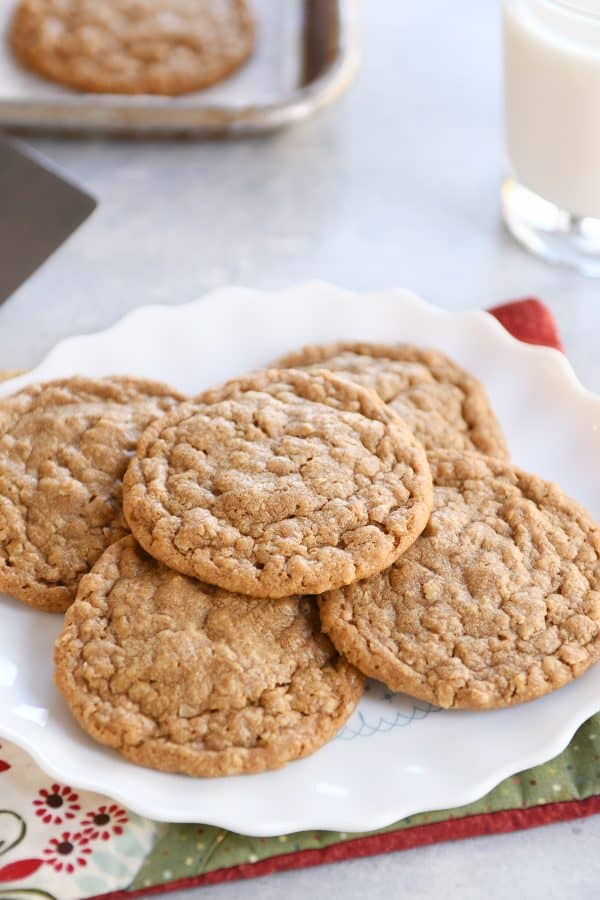 Gingerbread oatmeal cookies on white scalloped plate.