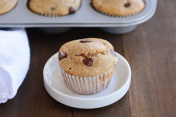 A chocolate chip banana muffin on a small white plate.