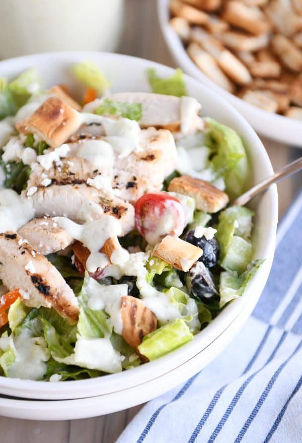 Fork on the side of a white bowl filled with greek Chicken salad with tzatziki dressing.