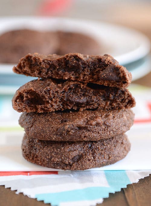 A stack of chocolate cookies with the top cookie split in half.