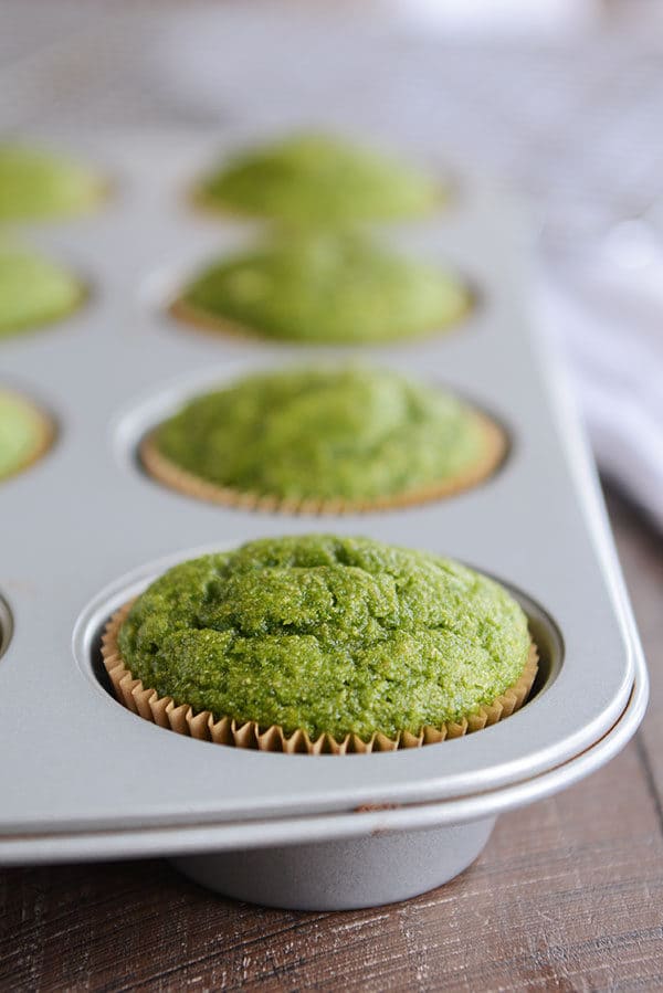 Green baked muffins in a muffin tin.
