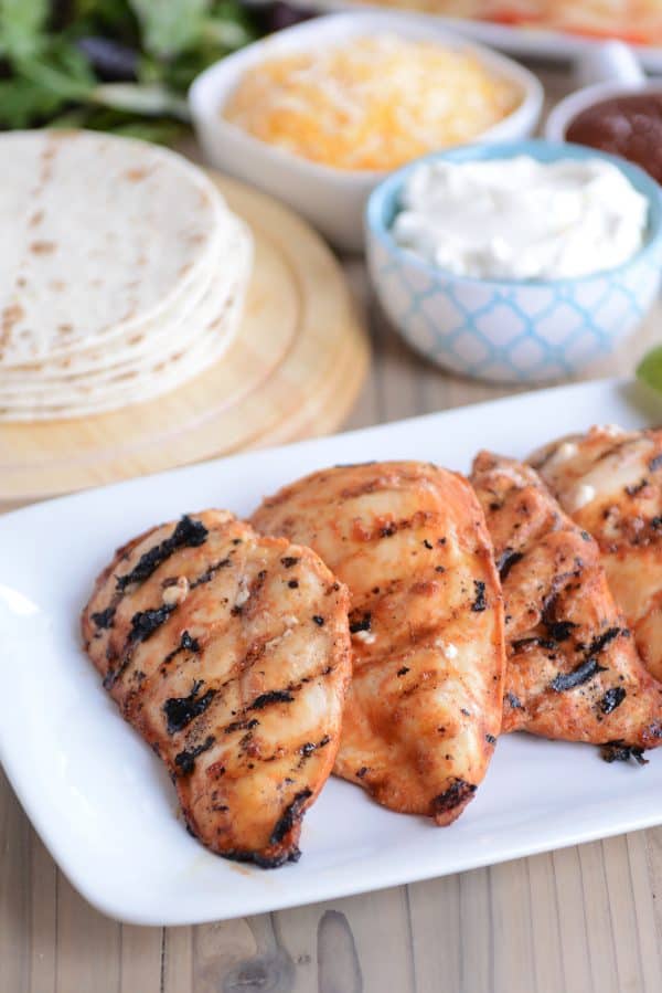 Three pieces of chipotle grilled chicken on white platter.