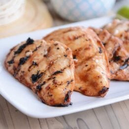 Three pieces of chipotle grilled chicken on white platter