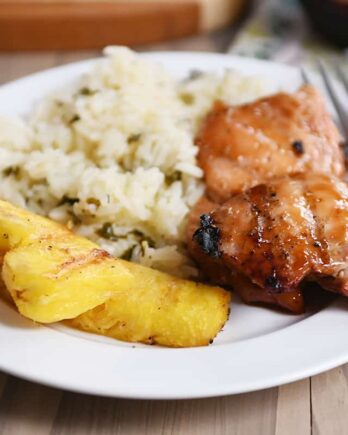 Grilled hawaiian chicken on plate with grilled pineapple and rice.
