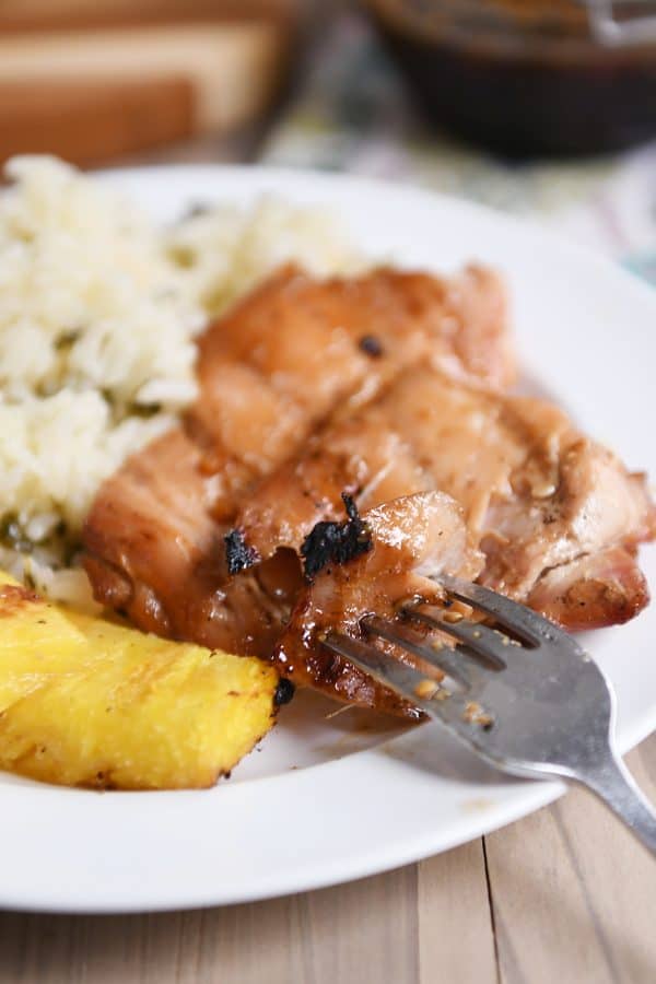 Grilled hawaiian chicken on plate with grilled pineapple and rice.