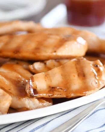 White platter of grilled sweet and sour chicken pieces.